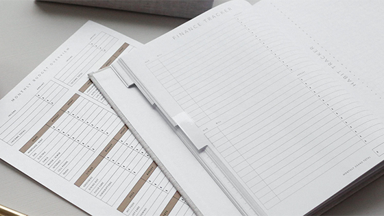 a blank financial tracker booklet sits on top of an expenses paper; image used for blog post about the 2021 Health Savings Accounts released by the IRS a blank financial tracker booklet sits on top of an expenses paper; image used for blog post about the 2021 Health Savings Accounts released by the IRS