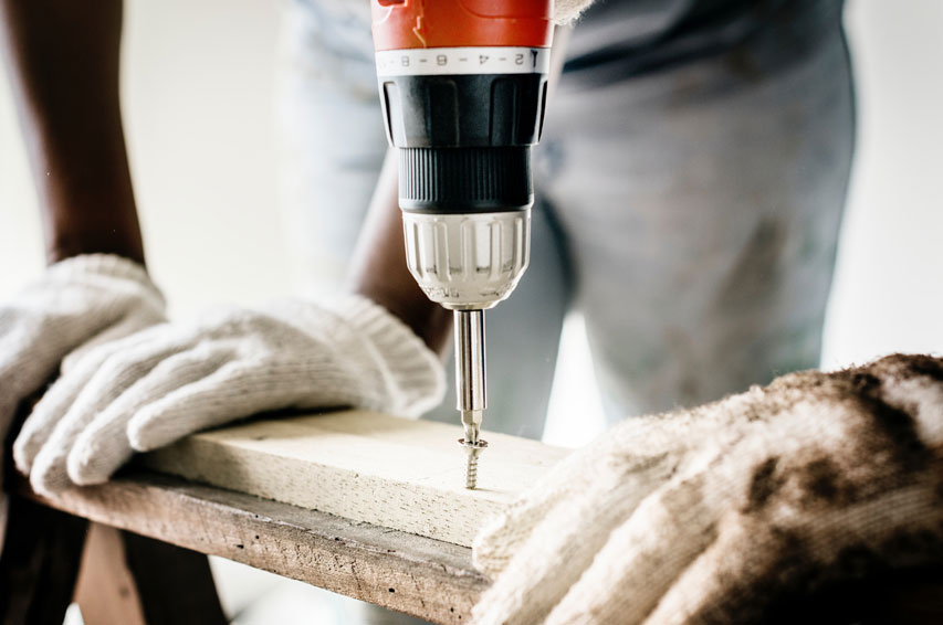construction workers drilling wood planks