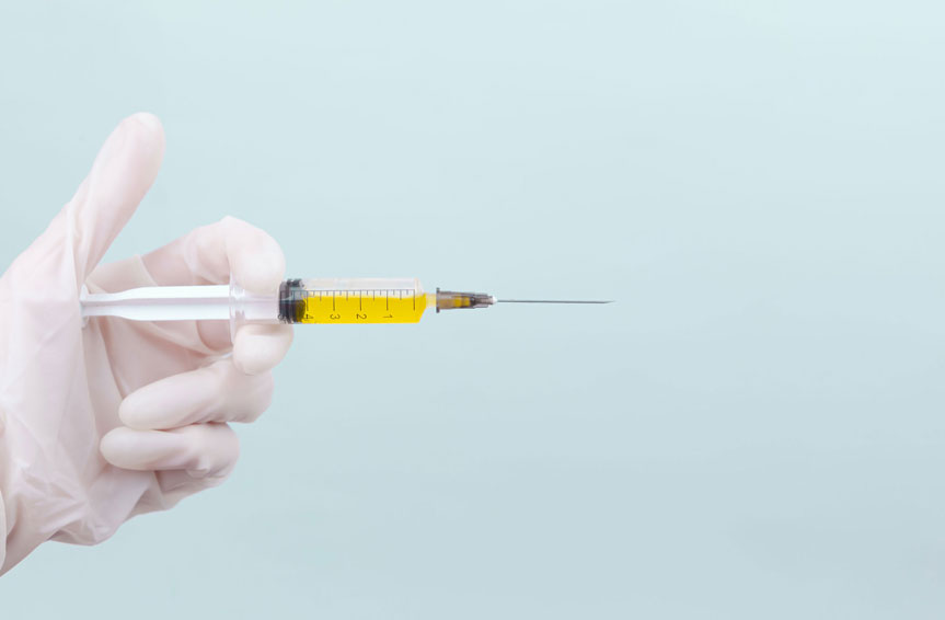 Syringe held with medical gloves