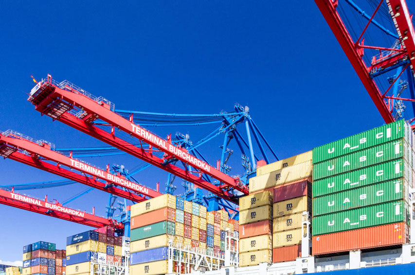 container ship at the port with green and yellow cargo containers