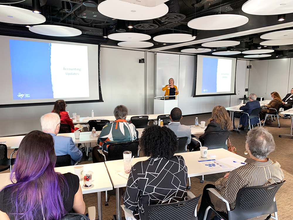 A photo of a room filled with people in seats listening to a speaker for the PKF Texas seminar, "2022 Accounting and Tax Updates and Changes for Not-for-Profits"