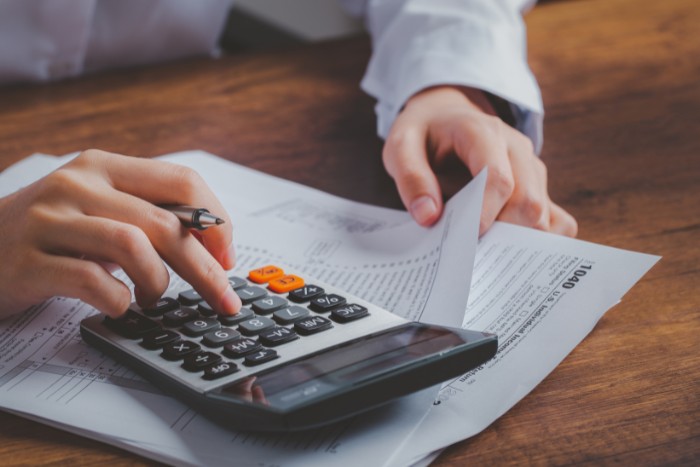Calculating income tax figures while organizing IRS Form 1040 paperwork